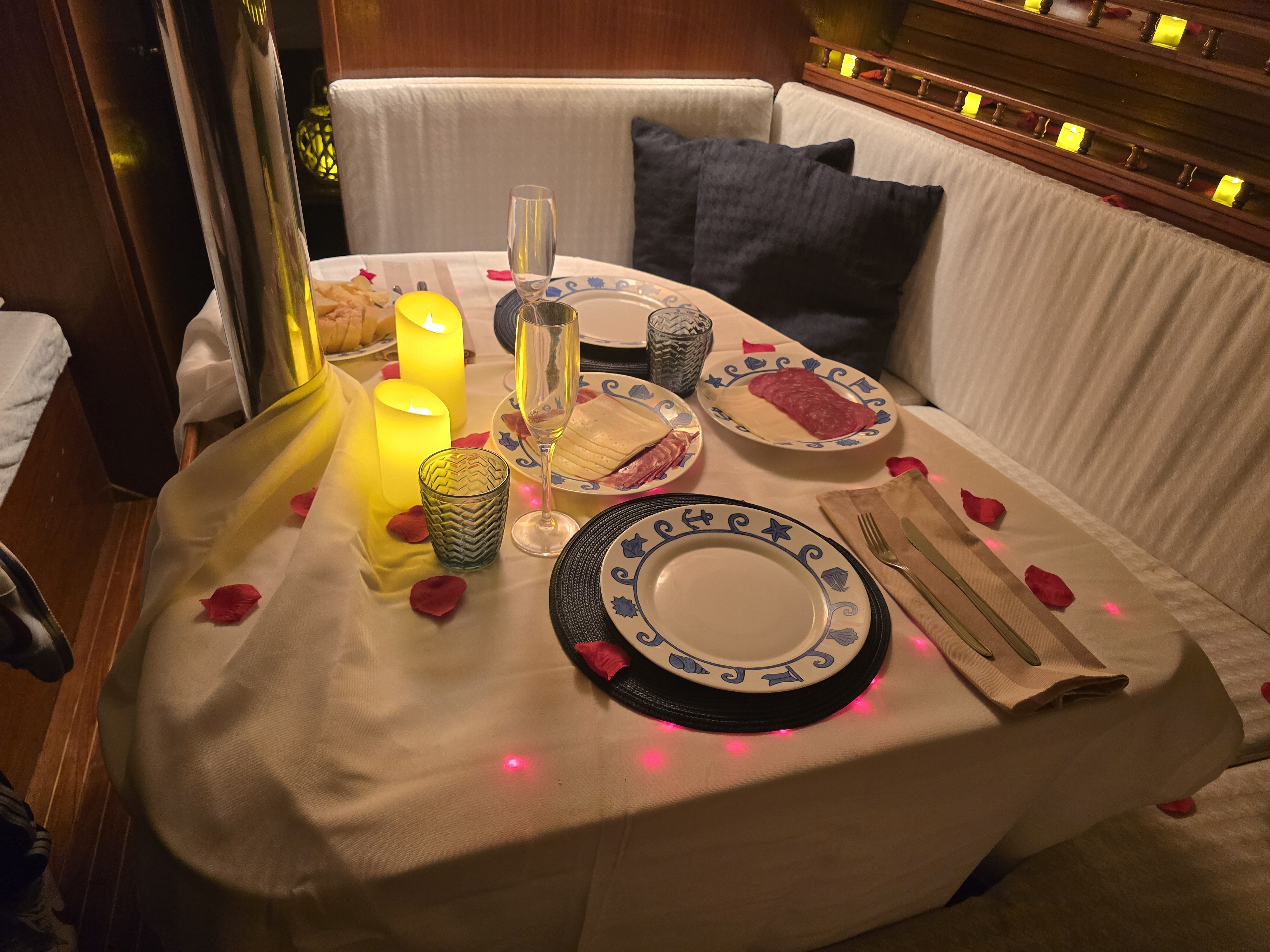 Cena romántica privada en la cubierta del velero bajo las estrellas